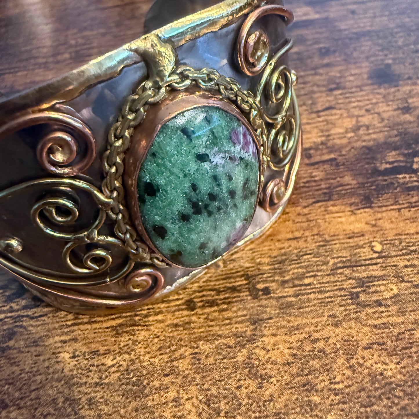 Ruby Zoisite natural stone wide cuff bracelet in mixed metals with copper scrollwork and chain accents.