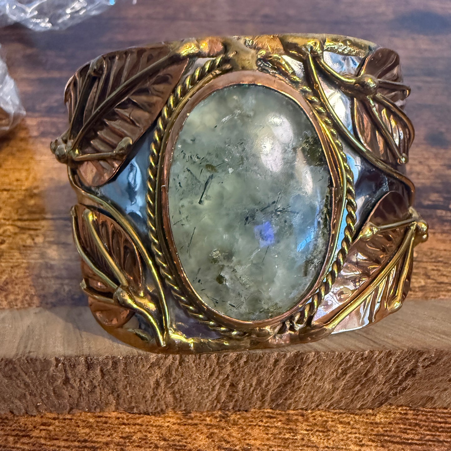 Moss agate centerpiece in a wide mixed-metal cuff bracelet with copper leaves and rope-braid edge.