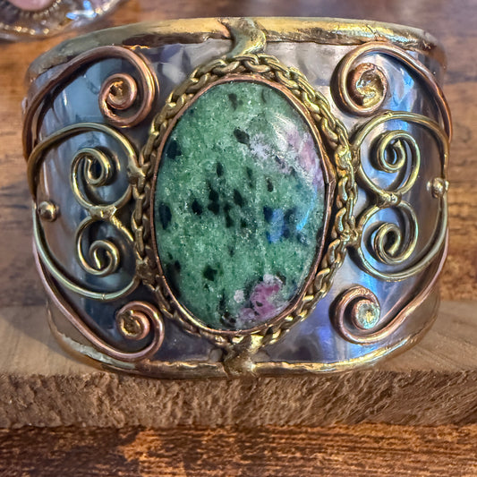 Ruby Zoisite natural stone wide cuff bracelet in mixed metals with gold-toned scrollwork bezel.