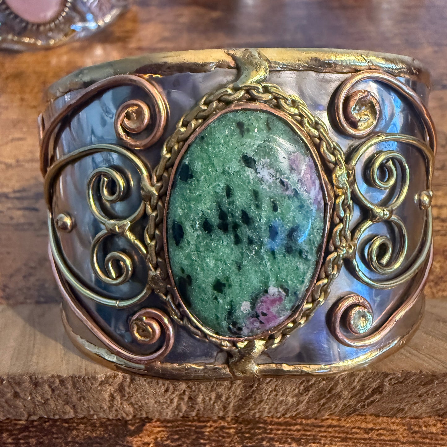 Ruby Zoisite wide cuff bracelet with mixed metals, copper wire scrollwork and a green speckled centerpiece.