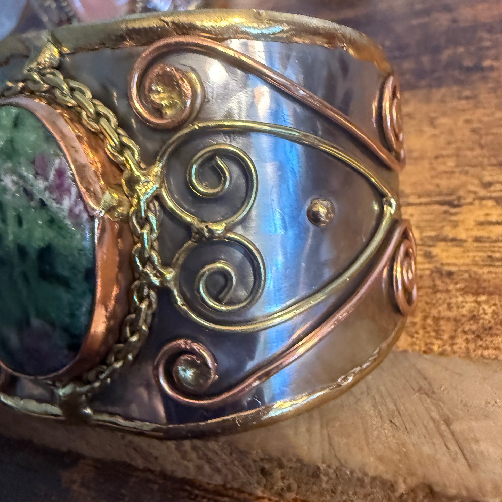 Ruby Zoisite natural stone wide cuff bracelet in mixed metals with copper wire scrollwork and chain accents.