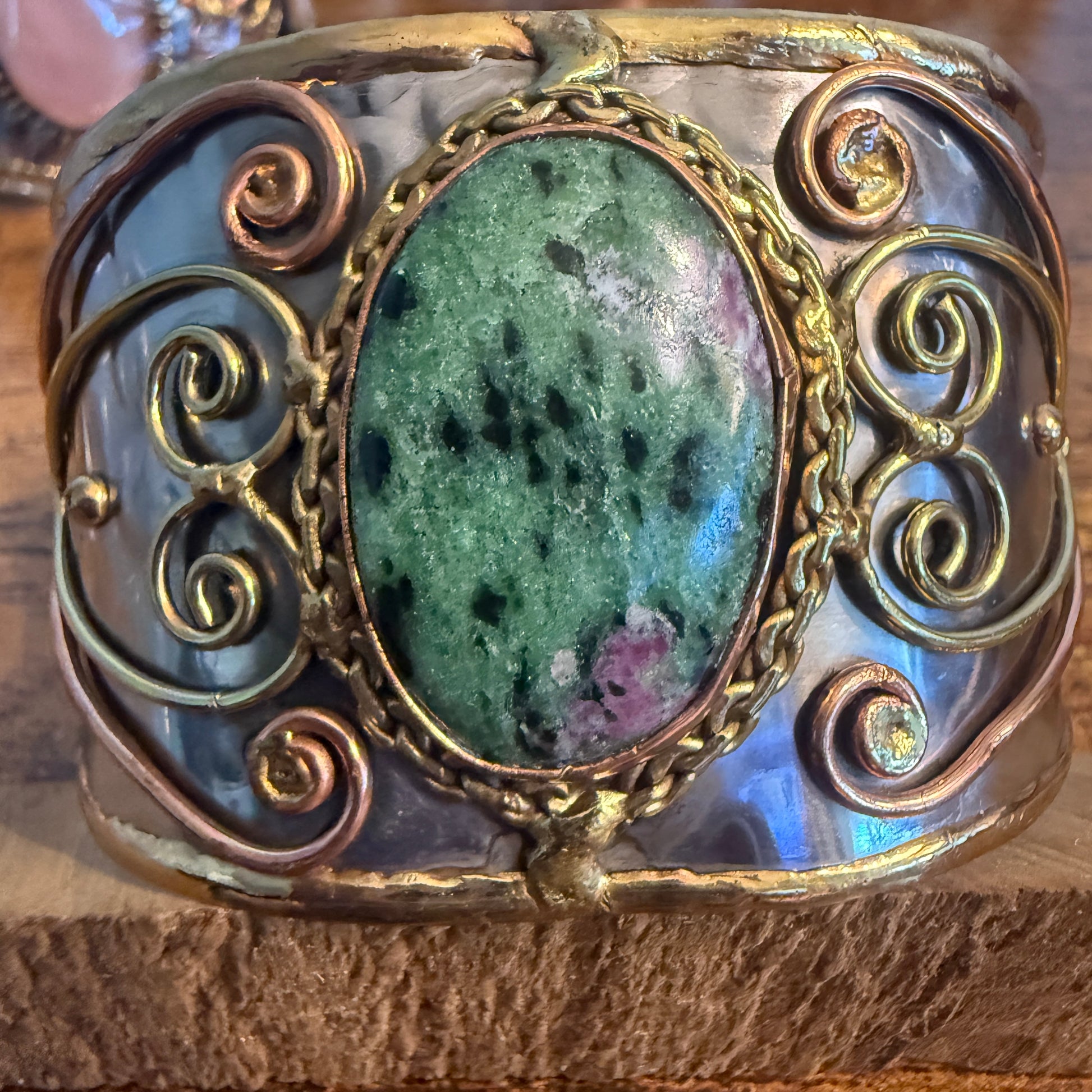 Ruby Zoisite natural stone wide cuff bracelet with mixed metals and ornate wire scrollwork.