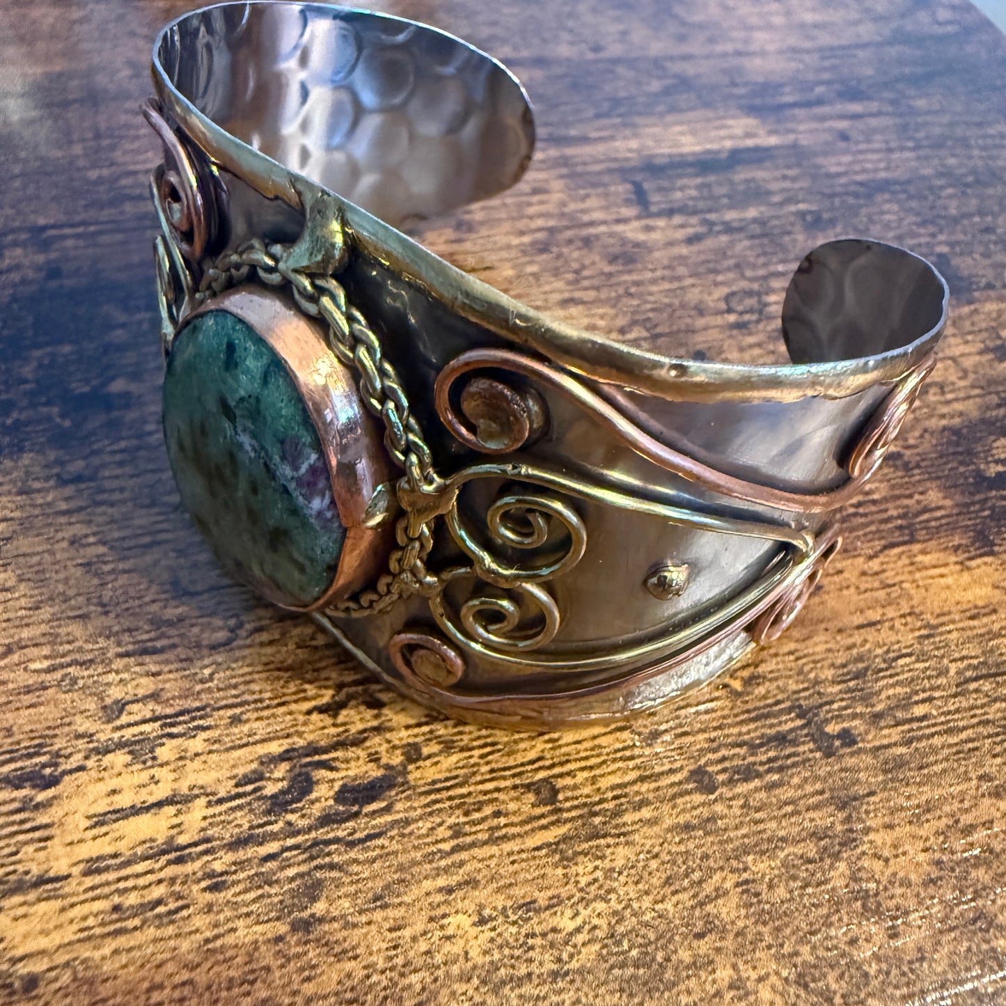 Ruby Zoisite natural stone wide cuff bracelet in mixed metals with copper scrollwork and chain accents.