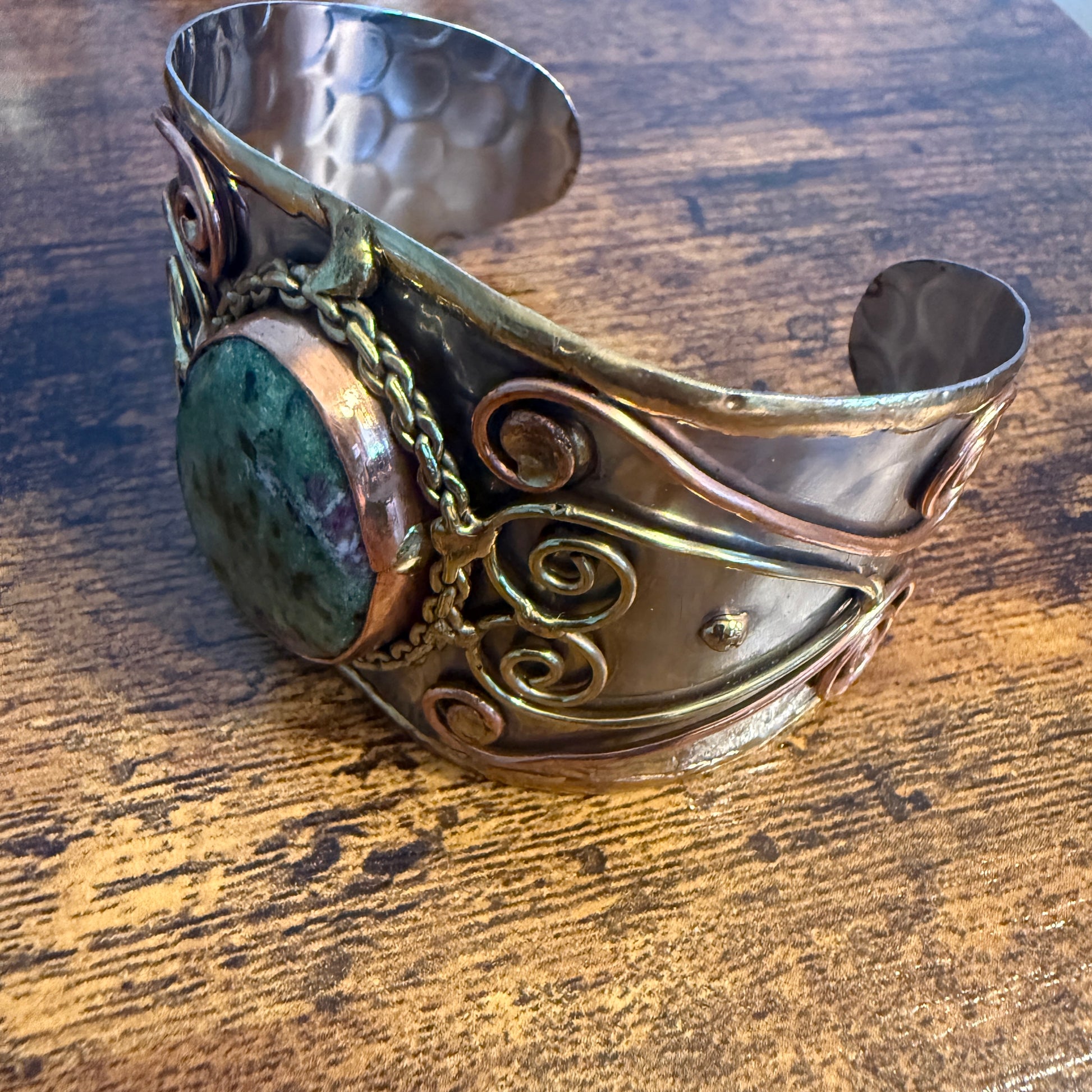 Ruby Zoisite natural stone wide cuff bracelet in mixed metals with copper scrollwork and chain accents.