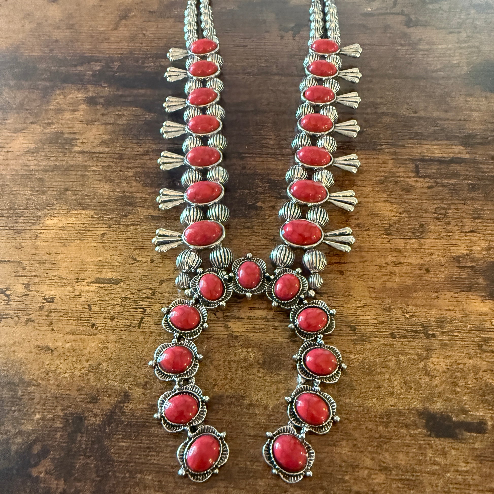 Two-strand squash blossom necklace with red stones and faux silver pearl beads, western-inspired statement piece.